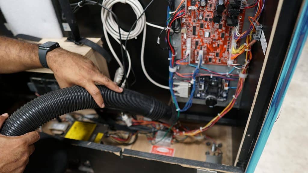 Vacuuming inside arcade cabinet. 